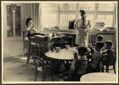 «Nos Petits». Дети завтракают, Жанна стоит у окна.
